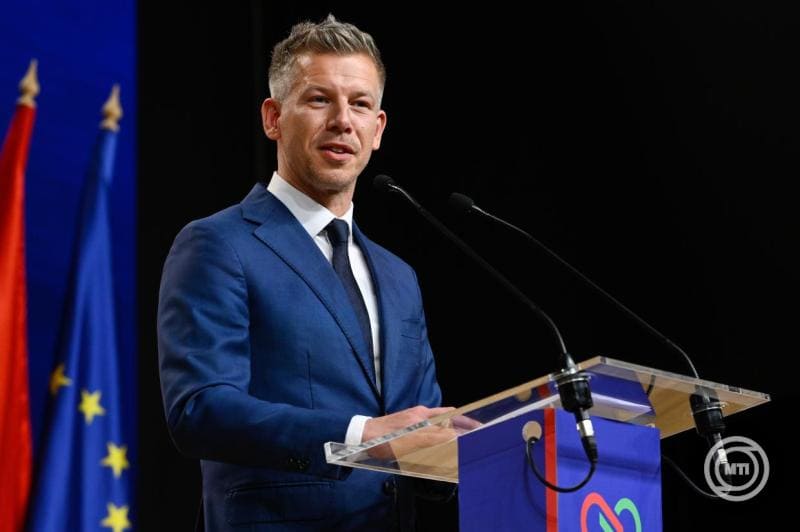 Magyar Péter a színpadon, politikus beszédet tart, háttérben magyar és EU zászlók.