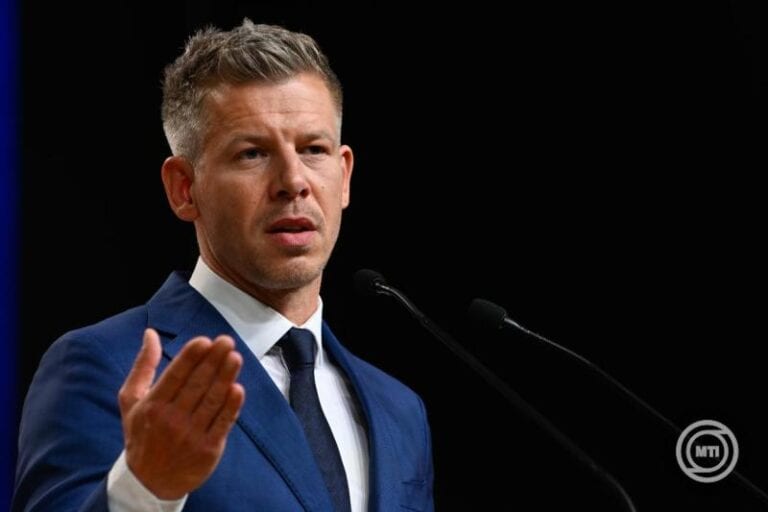 Magyar Péter a nyilvánosság előtt beszél, kék öltönyben.