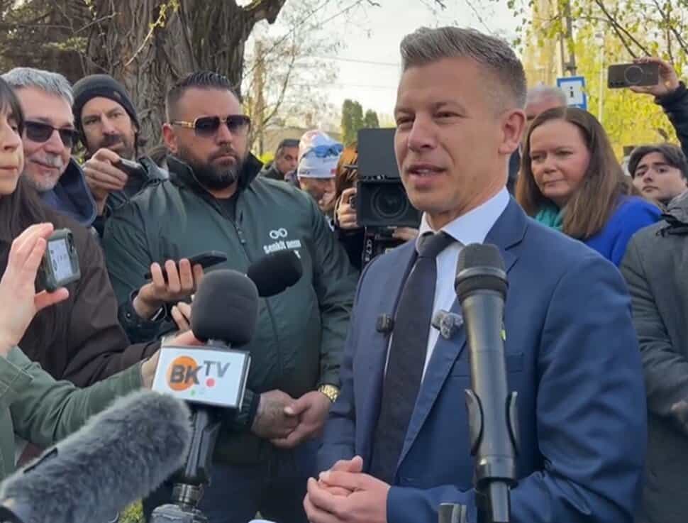 Magyar Péter a Tisza Párt elnöke szavazás közben, körülötte újságírók és kamerások.