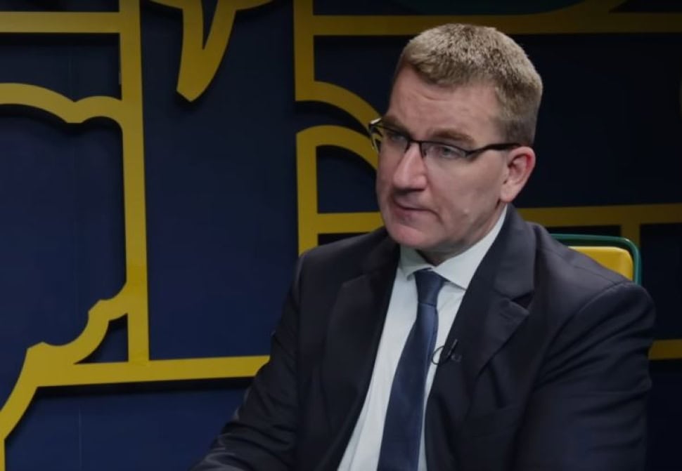 Politikus beszélgetés közben, komoly arckifejezéssel.