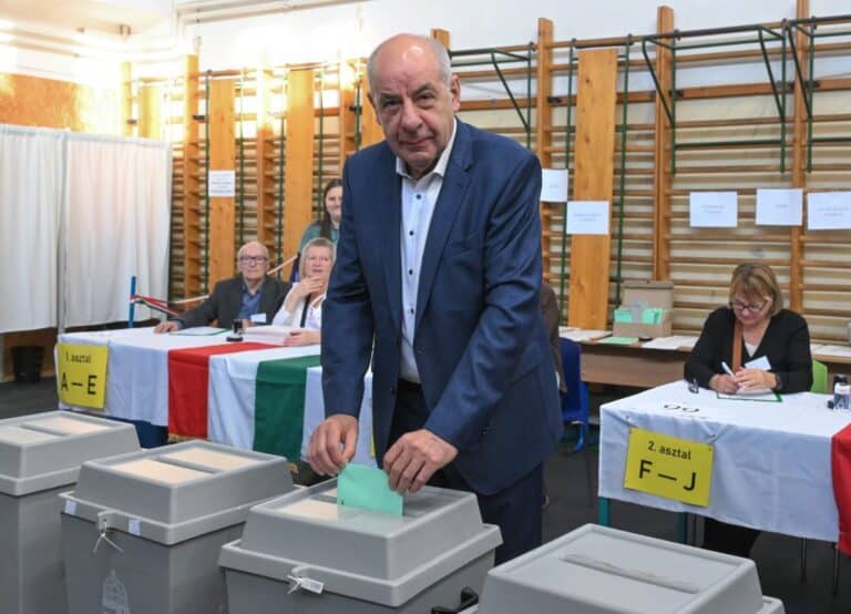 Egy férfi szavaz egy választási urnánál egy szavazóhelyiségben.