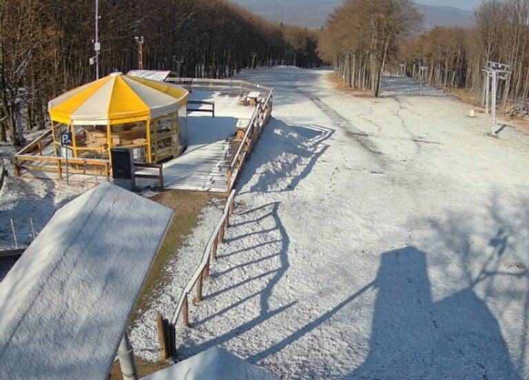 Havas sípálya Mátrában, napfényes időben, üres pályák és sífelvonók.