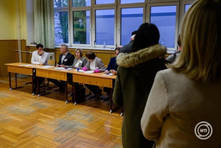 Csoportos beszélgetés egy tanácskozáson, ahol több résztvevő ül az asztalnál.