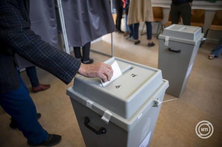 Emberek szavaznak egy szavazóurnánál a választáson.