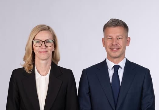 Vállalati vezetők portréja, üzleti öltözetben, mosolyogva.