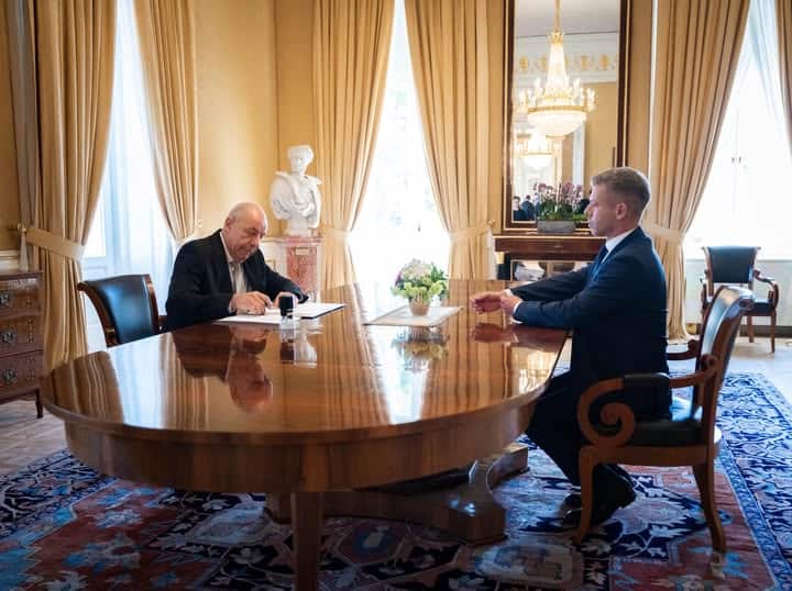 Elnöki találkozó két férfi között egy elegáns, klasszikus szalonban, nagy ablakokon keresztül termés.