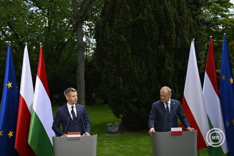 Magyar és európai zászlók a sajtótájékoztatón, két politikus beszél egymással a természe.
