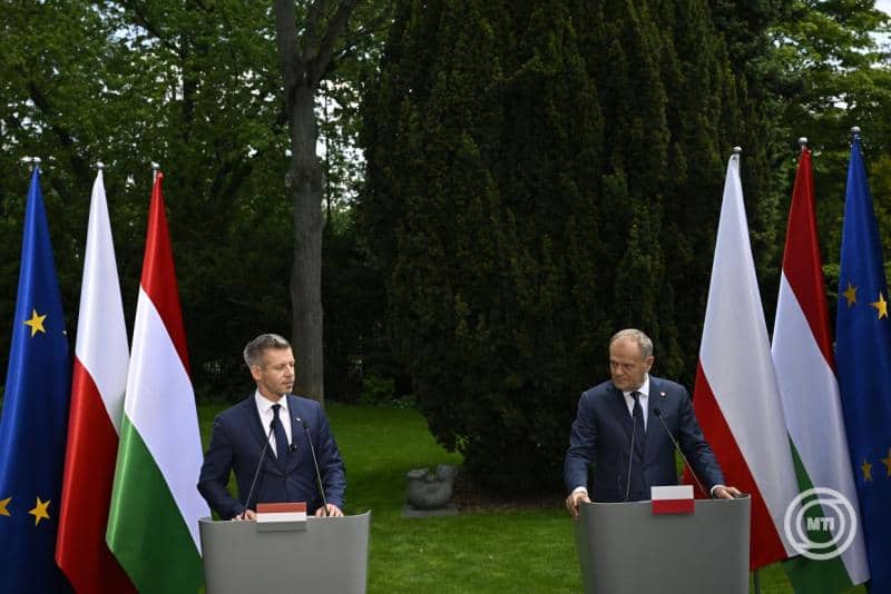 Magyar és európai zászlók a sajtótájékoztatón, két politikus beszél egymással a természe.