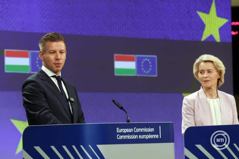 Budapesti sajtótájékoztató az Európai Bizottság képviselőivel, magyar és EU zászlókkal a.