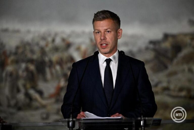 Emberi férfi beszédet mond egy konferencián, háttérben hulladéklerakó.