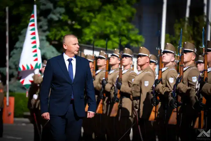 Magyar katonai tisztviselő felvonulás közben, egyenruhában és sapkában.