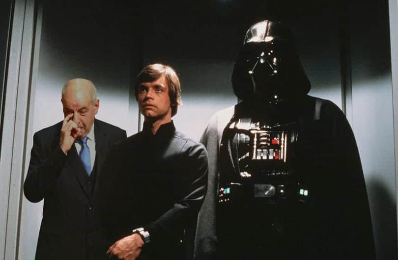 Darth Vader és két ember a Csillagok háborúja filmjéből, sötét háttérrel.