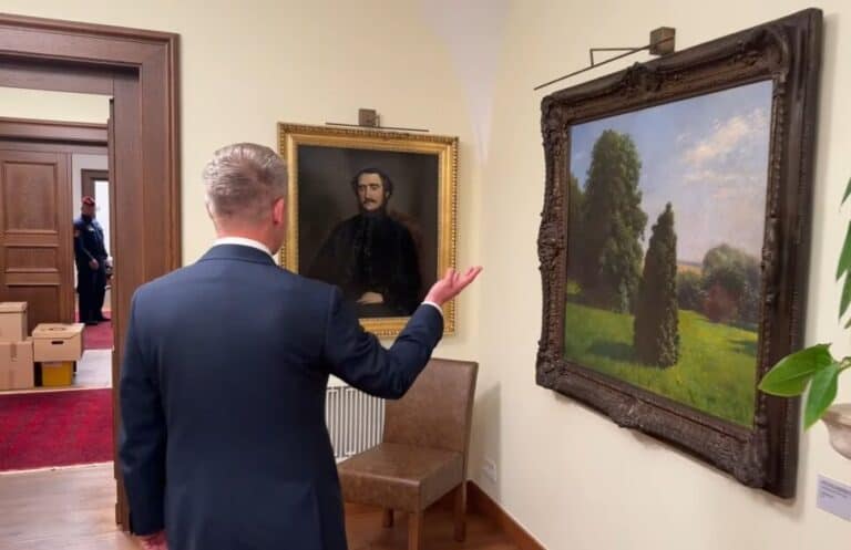 Egy férfi nézi a Karmelita-kápolnában kiállított festményeket.