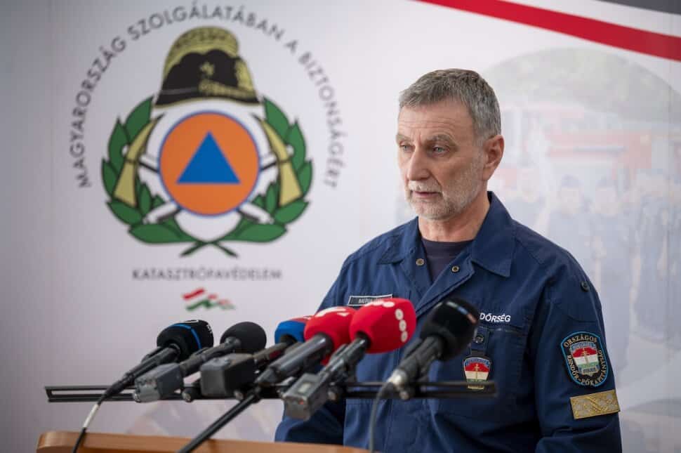 Védelmi szakember beszél a sajtó előtt, háttérben a Magyar Honvédség emblémája.