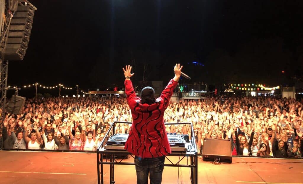 DJ Dominique a színpadon, hatalmas közönség előtt.