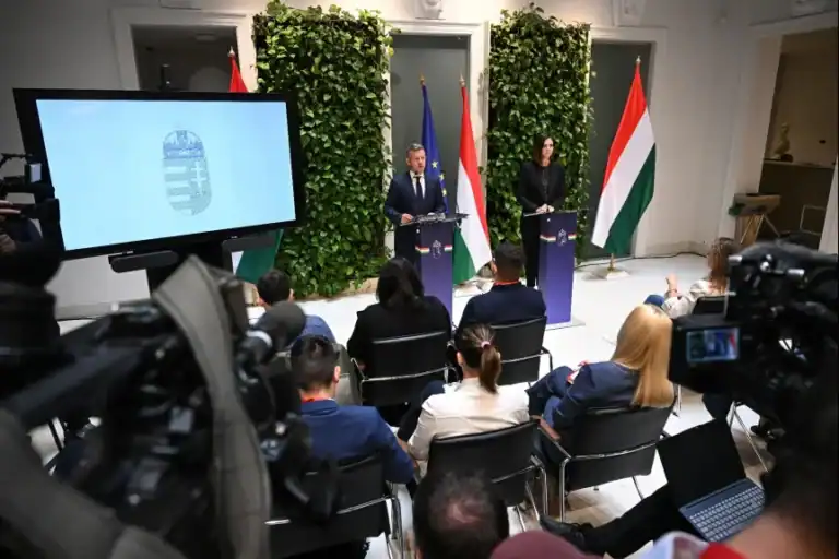 Magyar kormány sajtótájékoztató, két politikus beszél a mikrofonok előtt.
