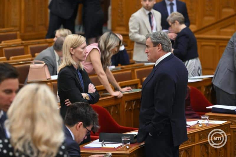 Két politikus beszélget a parlamenti ülésen.