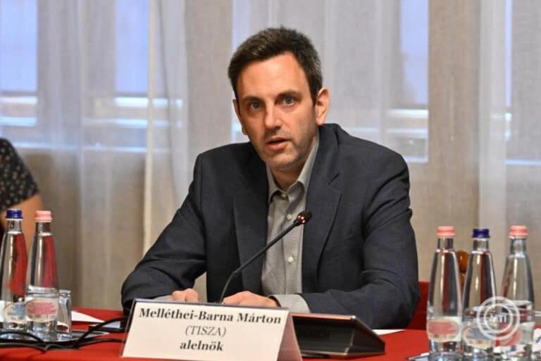 Melléthei-Barna Márton az asztalnál ül, beszél egy konferencián.