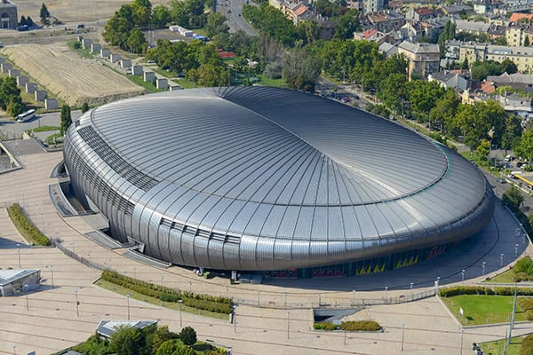 Modern stadion épülete fényes fémfelülettel és kör alakú formával.