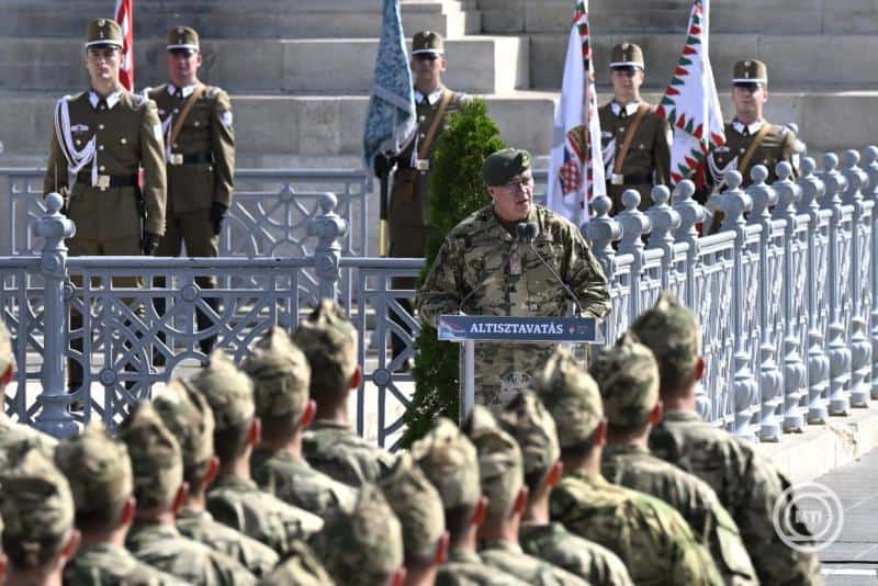 Magyar katonák hallgatnak egy beszédet egy emelvényen.