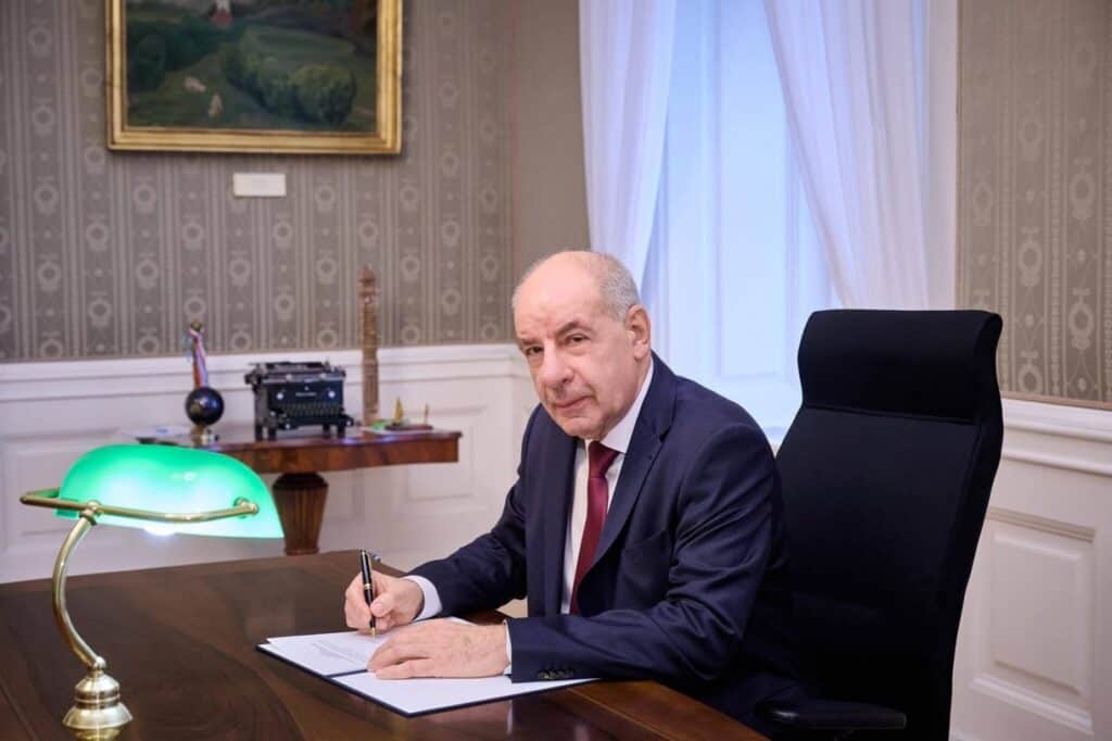 Sulyok Tamás íróasztalnál ül, írja alá a törvényeket.