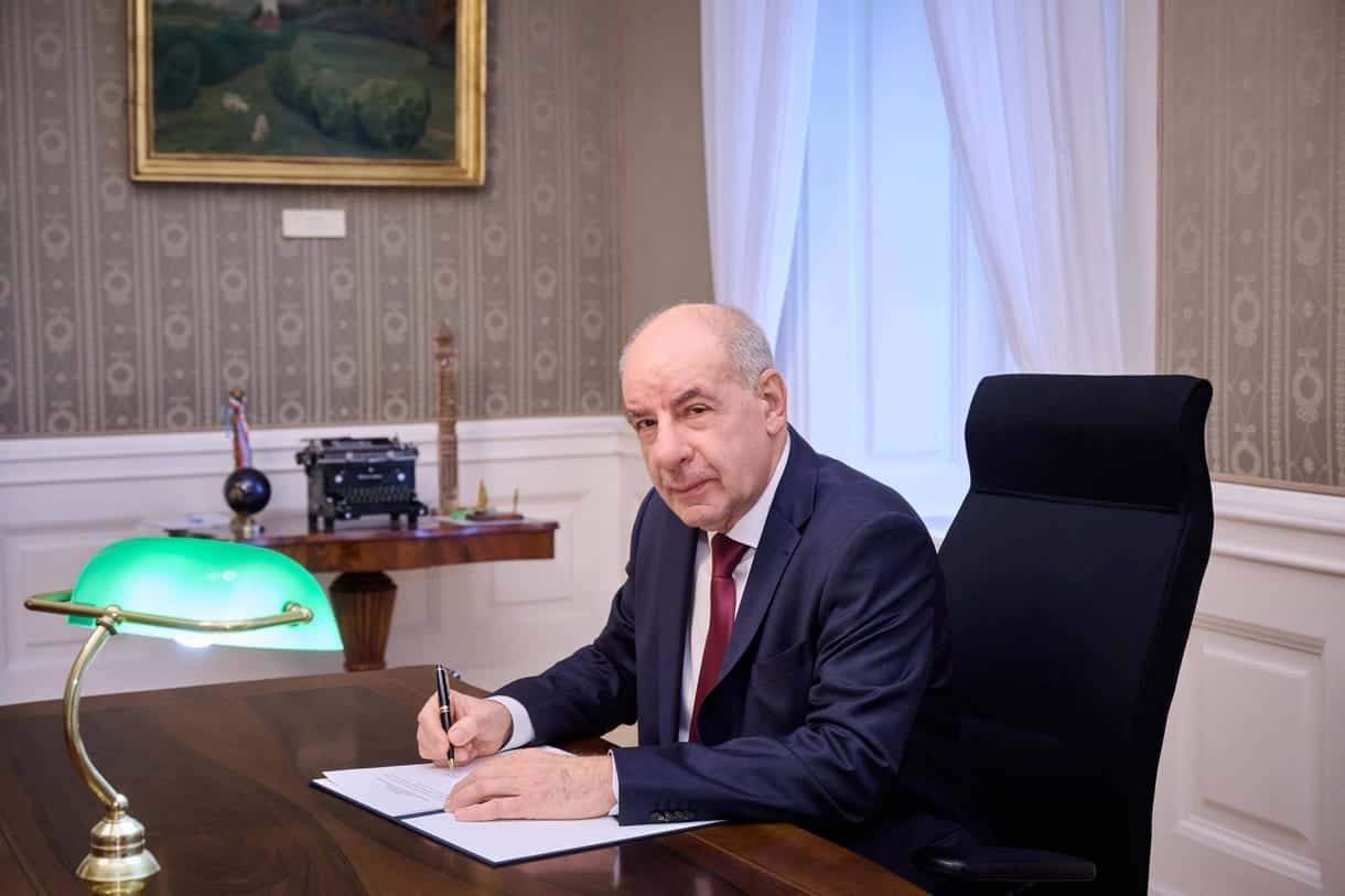 Sulyok Tamás íróasztalnál ül, írja alá a törvényeket.