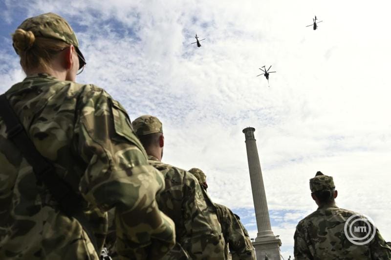 Magyar katonák figyelik a helikoptereket az égen.