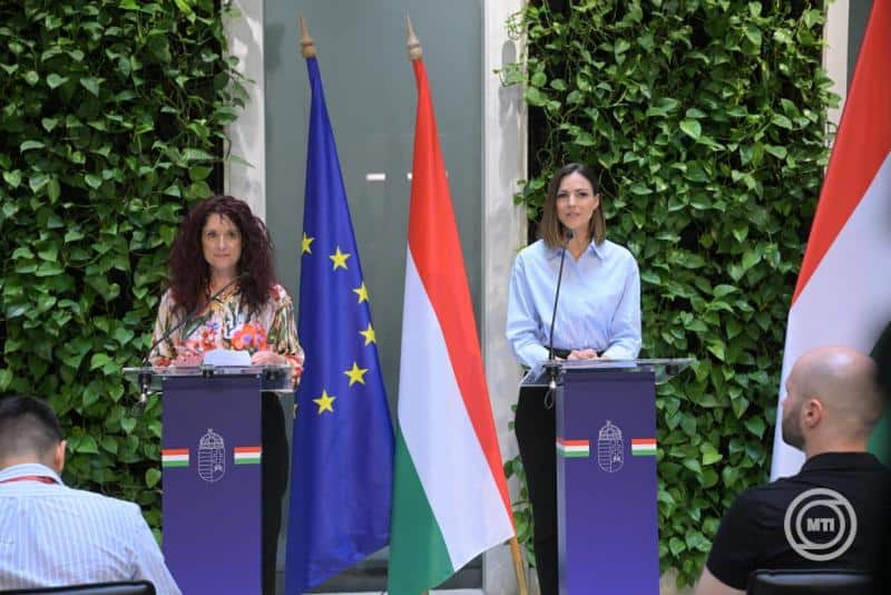 Magyar és európai zászlók mellett két nő beszél a mikrofonoknál.